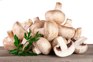 Champignon mushrooms on wooden table with white background