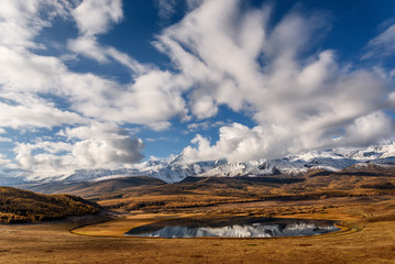 Fototapeta na wymiar lake mountains reflection snow clouds autumn