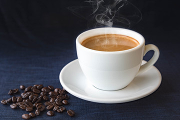 Coffee cup and beans on a dark background