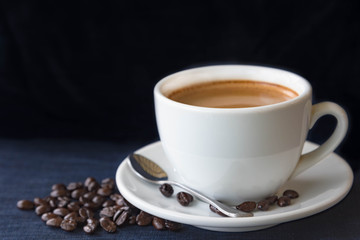 Coffee cup and beans on a dark background