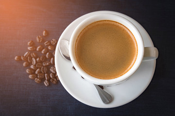 Coffee cup and beans on a dark background
