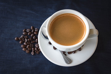 Coffee cup and beans on a dark background