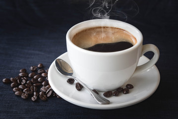 Coffee cup and beans on a dark background