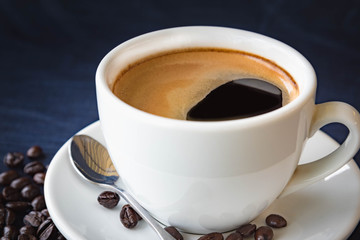 Coffee cup and beans on a dark background