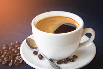 Coffee cup and beans on a dark background