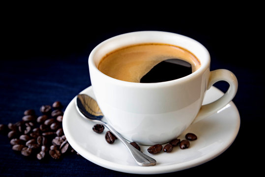 Coffee cup and beans on a dark background