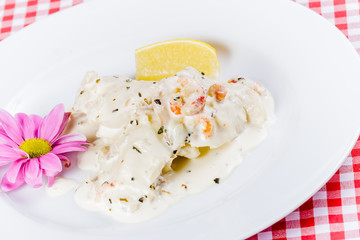 Pike Perch with cream sauce and shrimp on white plate