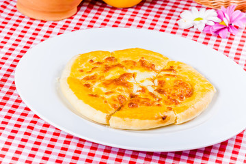 Khachapuri with cheese on white plate