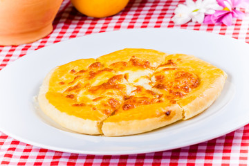 Khachapuri with cheese on white plate