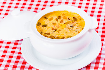 Cream soup with pumpkin in white bowl