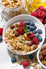homemade muesli with yogurt and berries for breakfast, vertical closeup