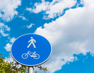 Pedestrian and bike sign under a cloudy sky