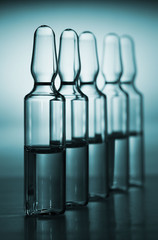 Row of ampulas with medicine on blue background