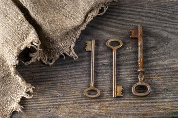 Old vintage books and keys on table on rustic wooden background.