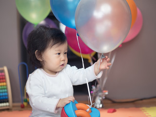 cute smiling baby girl play toy at home