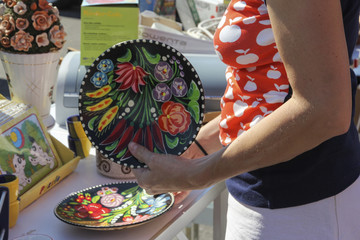 Woman examining colorful plates on a flea market