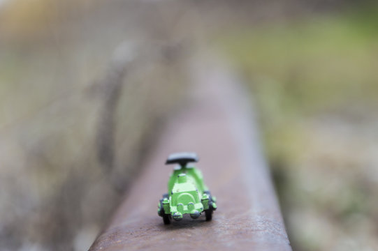 Green steel toy train in a blurred background, conceptual photo