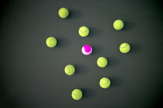 Pink tennis ball among greens