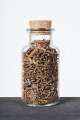 Dried dandelion roots herb inside a glass jar. Herbs and plants for tea.