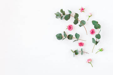 Flowers composition. Rose flowers and eucalyptus branches. Flat lay, top view