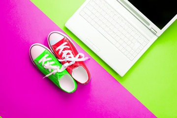 colorful gumshoes and silver laptop on the wonderful colorful background in pop art style