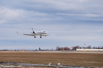 Fototapeta na wymiar Landing of the private passenger bizjet or bussines jet airplane at Vaclav havel airport in Prague, capitol of Czech Republic in the winter summer day.