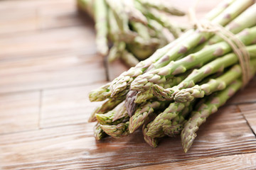 Bunch of green asparagus on brown wooden table