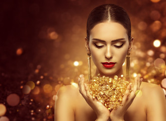 Fashion Model Holding Gold Jewelry in Hands, Woman Golden Beauty, Beautiful Girl Makeup and Luxury...