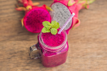 Smoothies of a red organic dragon fruit on an old wooden background