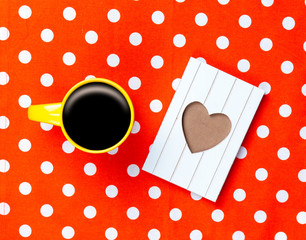photo of cup of coffee and cute postcard on the wonderful red dotted background in pop art style