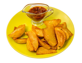 Fried potatoes with red sauce on a green plate isolated on white background