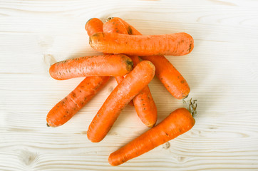 Fresh carrots on wooden table background