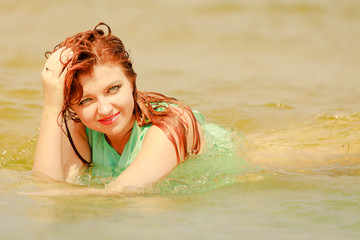 Redhead woman posing in water during summertime