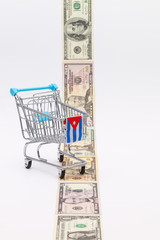 Strip of different us dollar banknotes and empty shopping trolley