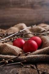 Three Easter eggs, spring branches on the material from the bag
