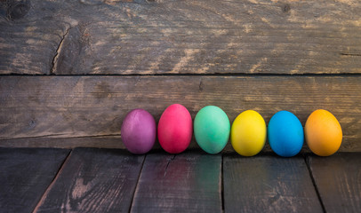 Colorful  easter eggs on wooden desk .