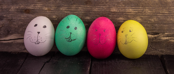 Funny easter eggs on rustic wooden planks