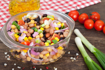 Three bean salad with sweetcorn, chickpeas and red onion in a vinaigrette dressing.