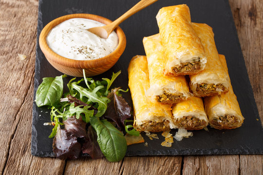 Fototapeta Crispy rolls borek with minced meat and eggs close-up on the table. horizontal