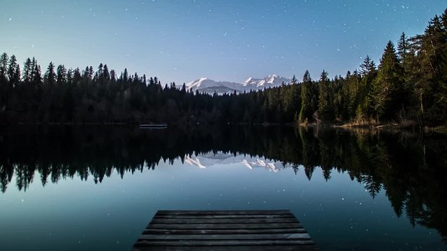 Beautiful timelapse of a Swiss lake in the mountains during the night.