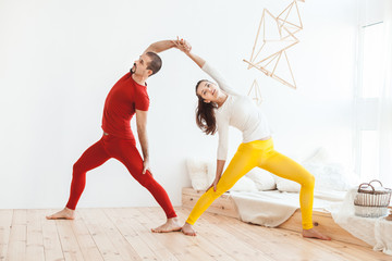 Young couple leads a healthy lifestyle, they do morning yoga gymnastics.