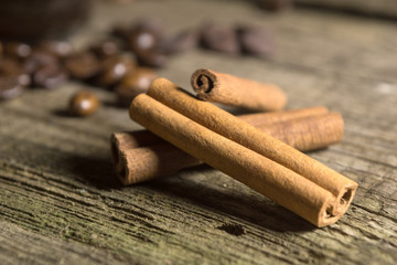 Cinnamon sticks with coffee grains on wooden background