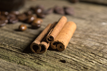Cinnamon sticks with coffee grains on wooden background