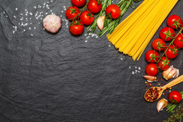 Pasta ingredients. Spaghetti with ingredients sweet basil, tomato, garlic and parmesan cheese on dark background. Top view