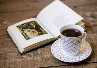 Vintage open book with cup of tea