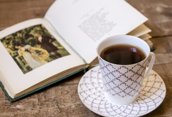 Vintage open book with cup of tea