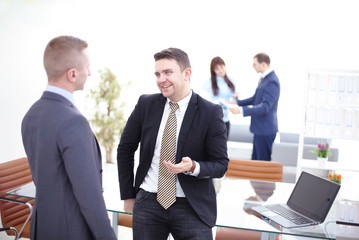 Fototapeta premium Successful team leader and business owner leading informal in-house business meeting. Businessman working on laptop in foregroun