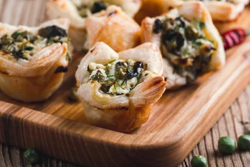 Keuken spatwand met foto Homemade spinach and feta cheese puff pastry cups © istetiana