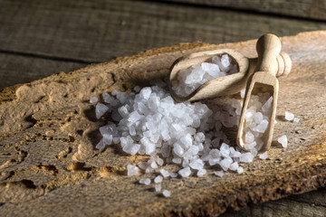 Cyprus sea salt flakes over bark on wooden background