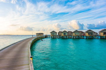 Beautiful sunrise with  water villas  in tropical Maldives island .